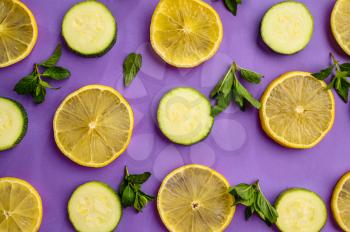 Fresh lemon and cucumber slices isolated on purple background. Organic vegetarian food, grocery assortment, natural eco products, healthy lifestyle concept