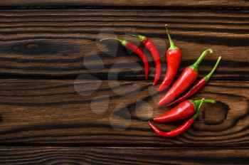 Fragrant red pepper isolated on wooden background, top view. Organic vegetarian food, grocery assortment, natural eco products, healthy lifestyle concept