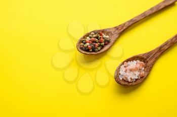 Fragrant spices in a spoon and red pepper isolated on yellow background, top view. Organic vegetarian food, grocery assortment, natural eco products, healthy lifestyle concept