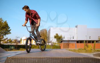 Bmx biker doing trick,teenager on training in skatepark. Extreme bicycle sport, dangerous cycle exercise, risk street riding, biking in summer park
