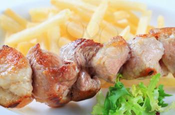 Pork skewer served with French fries