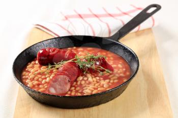 Baked beans and sausages on a fry pan
