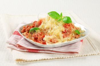 Spaghetti with minced meat and tomato sprinkled with cheese