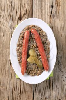 Cooked lentils with spicy sausages and pickles 
