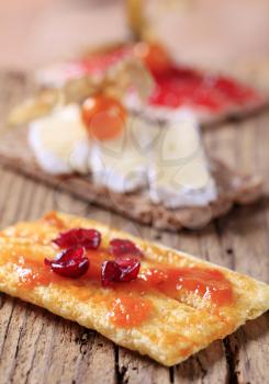 Slices of crisp bread with marmalade, cheese and jam
