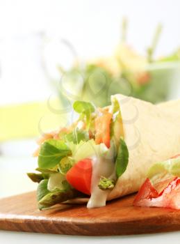 Tortilla filled with fresh vegetables and smoked salmon 