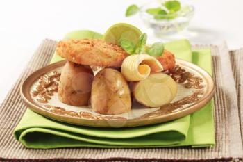 Fried fish fillet served with new potatoes 