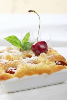 Fresly baked cherry sponge cake in a square ceramic dish
