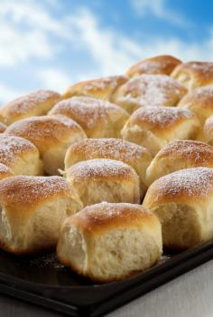 Sweet yeast buns on a baking tin
