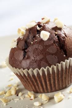 Chocolate muffin topped with chopped nuts
