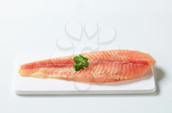 Raw skinless fish fillet on cutting board