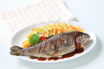 Grilled trout and French fries with barbecue sauce