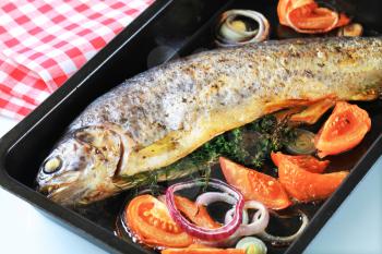 Herb-stuffed trout with tomatoes and onion