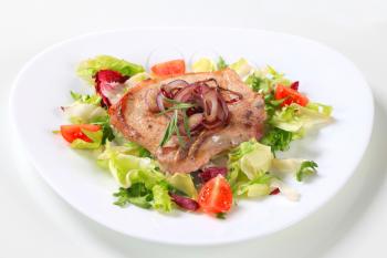 Pork cutlet on nest of green salad