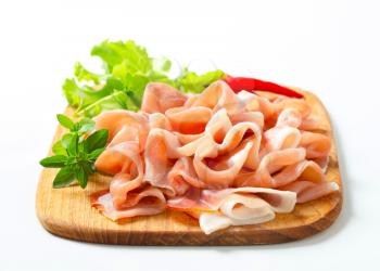 Thin slices of Prosciutto di Parma on cutting board