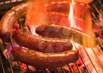 Grilling bratwursts on a charcoal grill