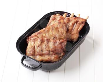 Oven-roasted rack of pork ribs in a pan