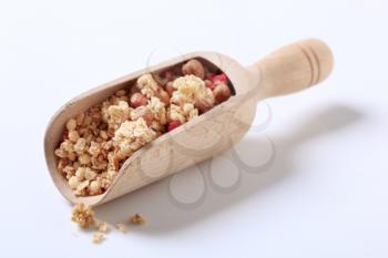 Scoop of strawberry granola cereal with hazelnuts