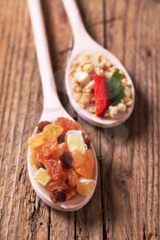 Nut granola and dried fruit on wooden spoons
