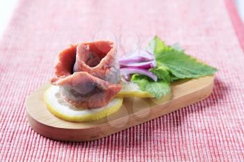 Skinless fish fillet (rolled up) with slices of lemon and onion