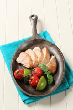 Slices of pan roasted chicken breast on a skillet