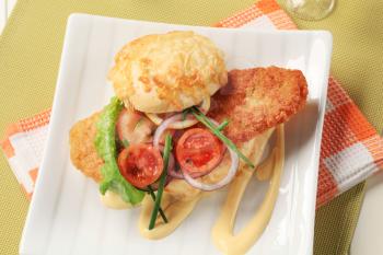Fried fish sandwich with vegetable garnish and mayonnaise