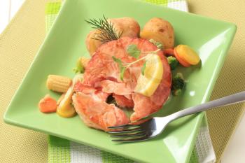 Salmon burger patty with mixed vegetables and potatoes