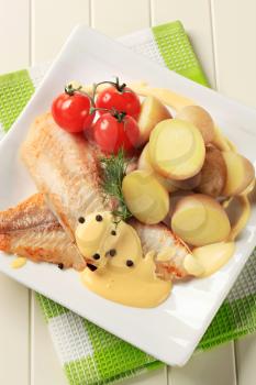 White fish fillets with new potatoes and Hollandaise sauce