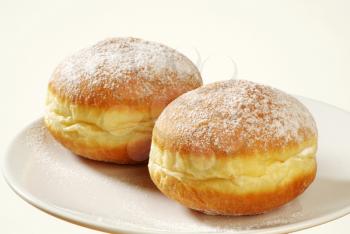 Two doughnuts
 sprinkled with powdered sugar - studio