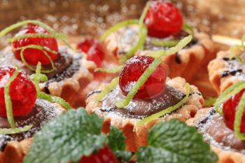 Chocolate filled tartlets topped with maraschino cherries