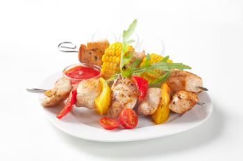 Grilled meat and vegetable on skewers and ketchup