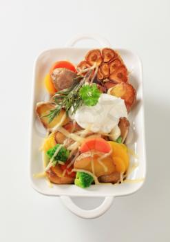 Baked potatoes and mixed vegetables topped with cheese
