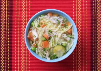 Bowl of chicken soup with noodles and vegetable