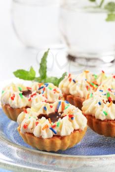 Chocolate and cream tartlets decorated with sprinkles