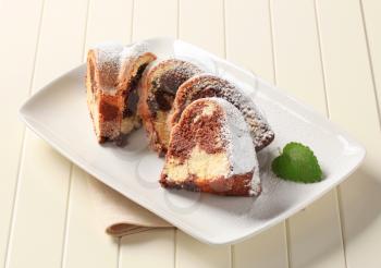 Slices of marble cake sprinkled with icing sugar