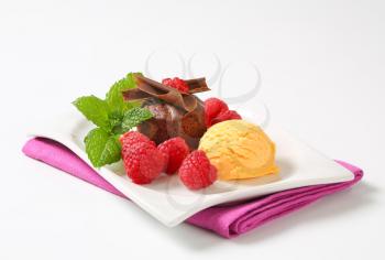 Mini chocolate cake served with fresh raspberries and scoop of ice cream