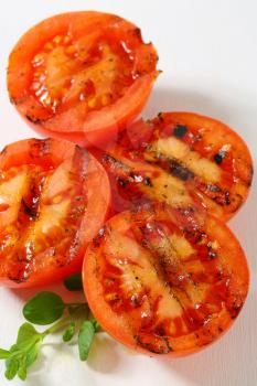 Grilled tomatoes on white cutting board