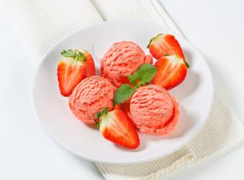 Scoops of strawberry ice cream with fresh fruit