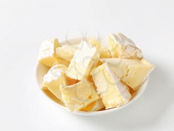 Pieces of French white rind cheese in a bowl