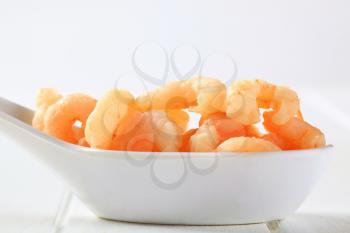 Cooked shrimps on a porcelain spoon