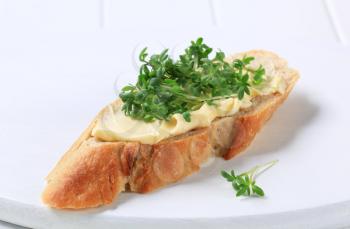 Slice of baguette with butter and cress