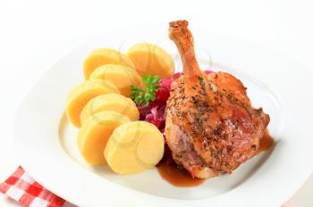 Dish of roast duck leg with potato dumplings and red cabbage