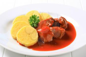 Pork meat in tomato sauce served with potato dumplings