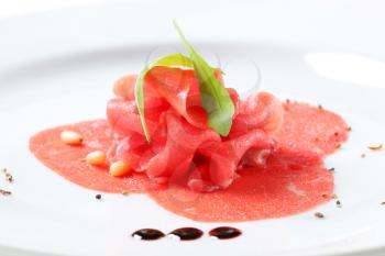 Thinly sliced raw beef with pine nuts