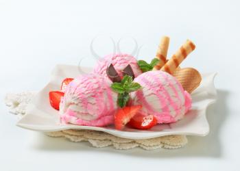 Ice cream sundae with strawberries and wafer rolls
