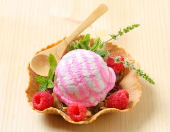Scoop of ice cream with fresh raspberries in a wafer bowl
