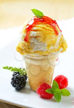 Ice cream cone drizzled with raspberry sauce