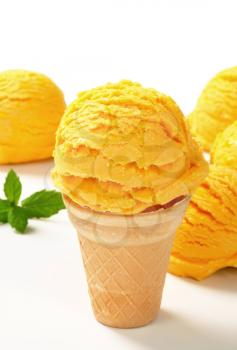 Scoop of yellow ice cream in a cone