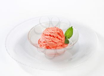 Scoop of pink fruit flavored sherbet in bowl