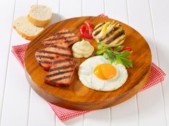 Grilled meatloaf with sunny side up fried egg and mustard
